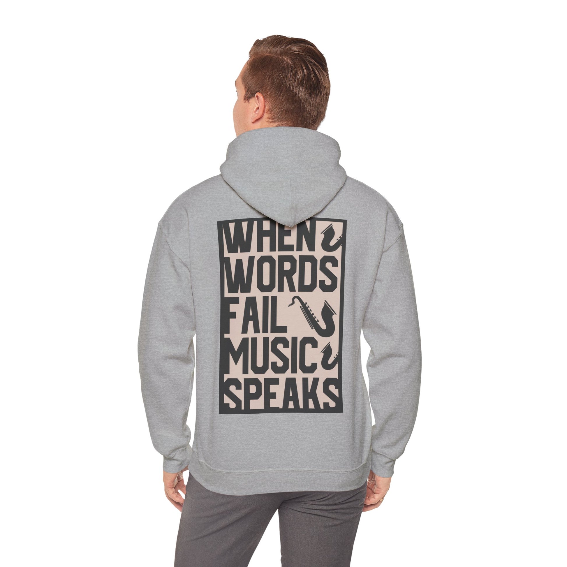 Sophisticated grey hoodie worn by a model, featuring a striking back print with the quote 'WHEN WORDS FAIL MUSIC SPEAKS' in bold typography and saxophone graphics.