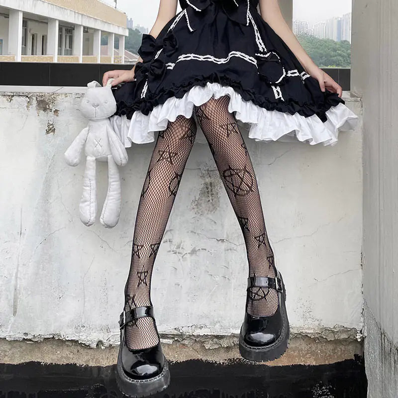 Dazzling Dreams Studio Pentacle Design Fishnet Stockings accentuating an elegant outfit, paired with a black dress and plush accessories, ideal for an edgy yet sophisticated look.