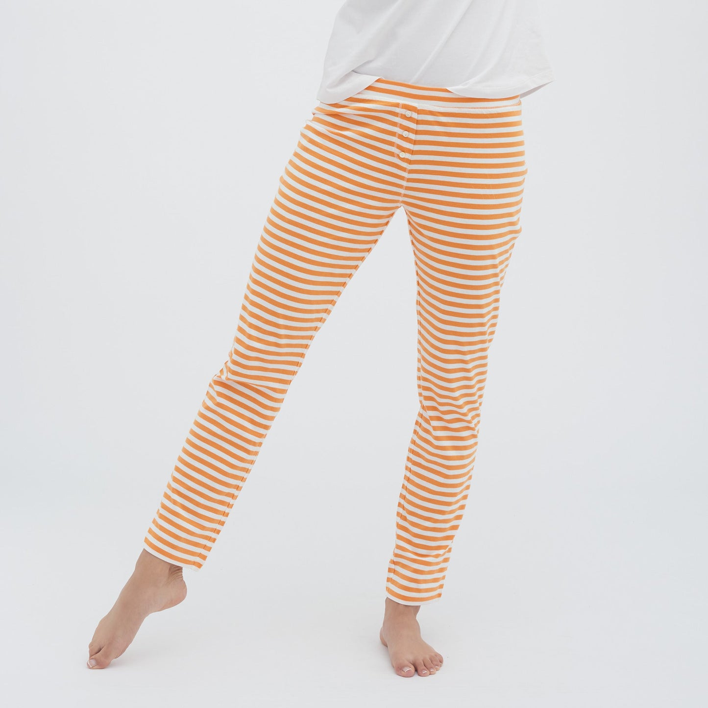 Woman wearing luxury organic cotton sleep leggings, highlighting the comfortable fit and stylish mother-of-pearl button accents.