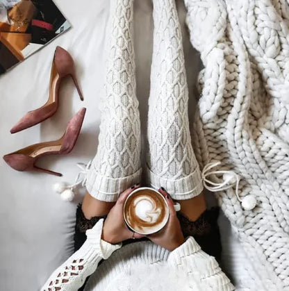 Luxury Women's Warm Winter Knitted Socks - Cozy, Cute, and Stylish Footwear for Every Occasion, displayed on a model relaxing at home with white knitted socks and holding a cup of coffee, complemented by elegant pink heels and a chunky knit blanket.