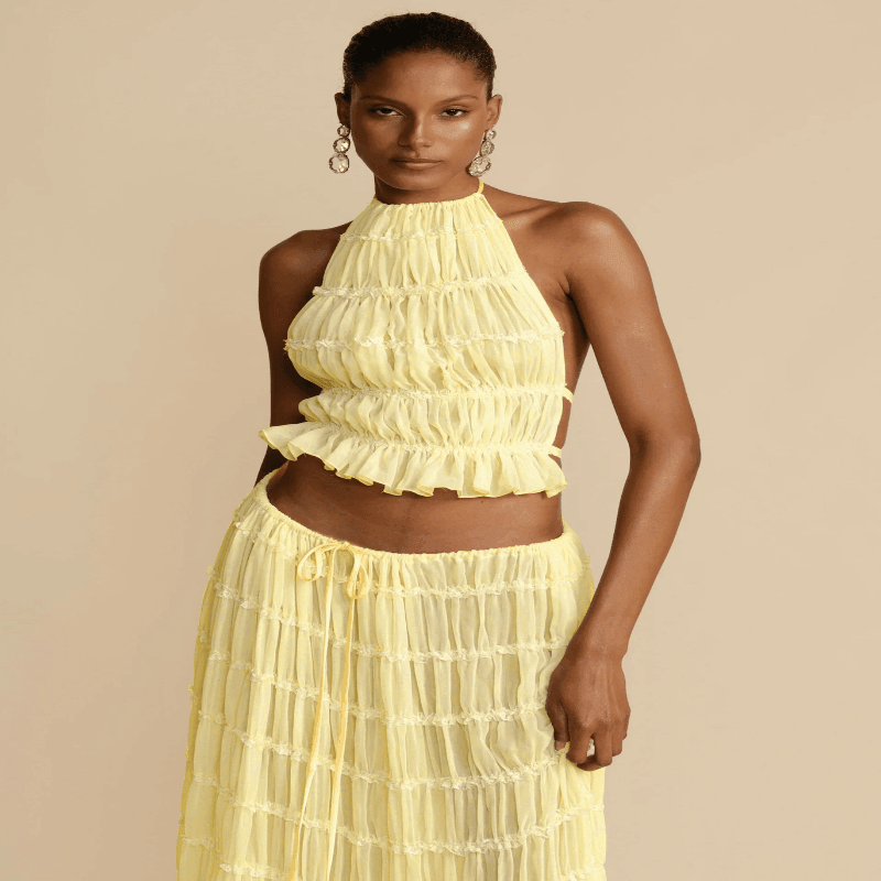 Full outfit display featuring the elegant sleeveless backless top with a flowing pleated long skirt, an ideal choice for summer events.