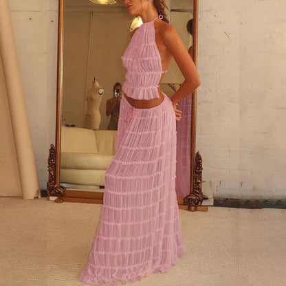 Fashion model wearing a stylish 2-piece outfit featuring a halter top and pleated skirt, embodying elegance and luxury for special events.