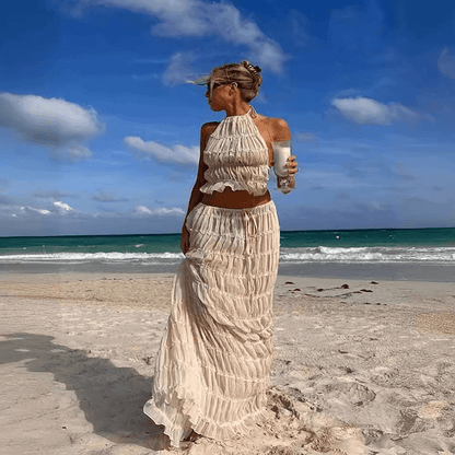 Model showcasing the stylish sleeveless halter top and pleated skirt set, epitomising high fashion and summer elegance.