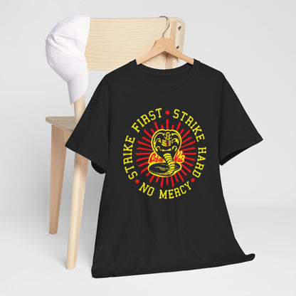 Chic arrangement of the Cobra Kai graphic t-shirt on a wooden chair, highlighting the eye-catching 'Strike First, Strike Hard, No Mercy' design for a fashionable yet relaxed vibe.