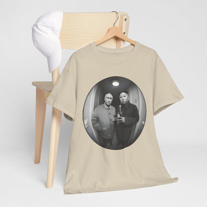 Luxury graphic t-shirt titled 'Meet The Neighbours Funny Gift' featuring a whimsical design of two leaders in a fisheye lens view, elegantly displayed on a hanger next to a chic white cap.