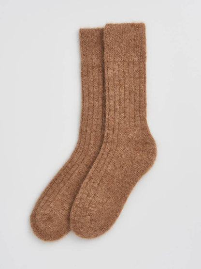 Chic presentation of ultra-soft bed socks made from alpaca wool, ideal for cosy nights and luxury gifting.
