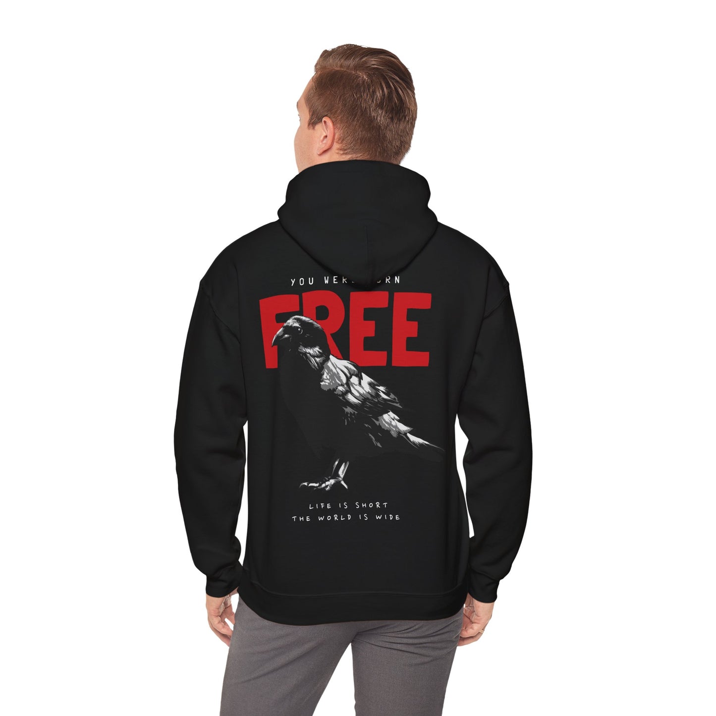Man showcasing a fashionable black hoodie adorned with a raven illustration and the empowering phrase 'YOU WERE BORN FREE', embodying a spirit of adventure and confidence.