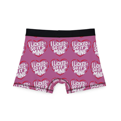 Valentine's Naughty Cheeky Men's Boxer Briefs viewed from the back, featuring a playful design with 'I LICKED IT SO IT'S MINE' in eye-catching red hearts on pink fabric.
