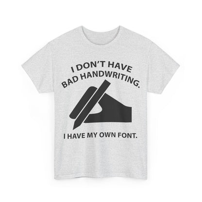 Front view of a stylish grey unisex T-shirt featuring the humorous text 'I DON'T HAVE BAD HANDWRITING. I HAVE MY OWN FONT.' in bold black print, perfect for expressing individuality.