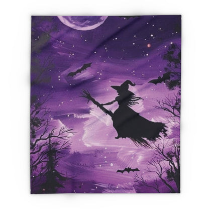 Decorative and Warm Halloween Spooky Arctic Fleece Blanket depicting a magical scene with a witch on her broomstick, set against a rich purple background filled with stars and bats.