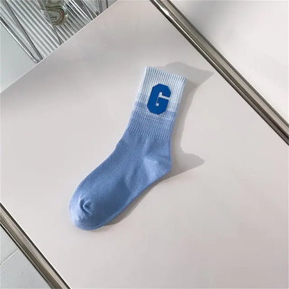 Luxurious Women's Tie-Dye Middle Tube Socks in light blue hues with a stylish letter 'G', perfect for adding a pop of colour to any ensemble.