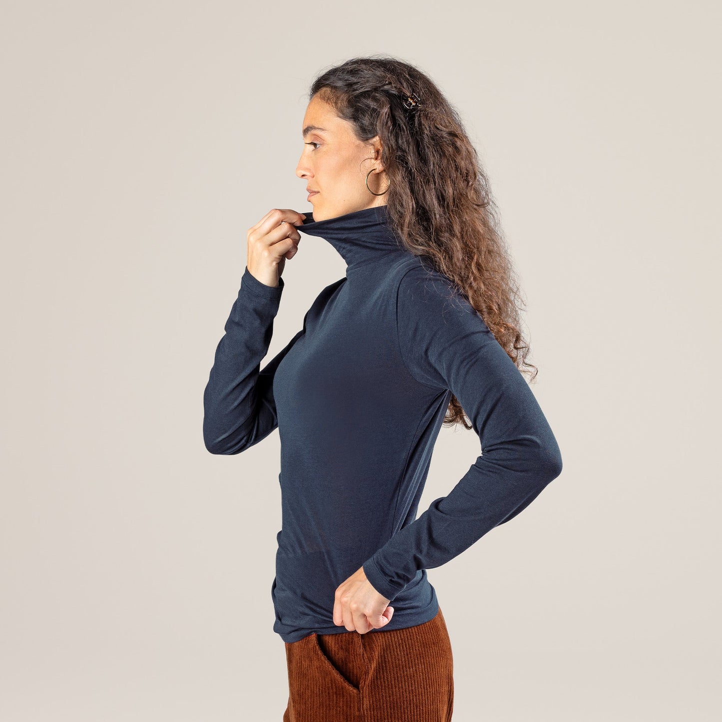 Model wearing a luxury organic cotton long-sleeved turtleneck t-shirt, illustrating versatility and chic styling in fashion.