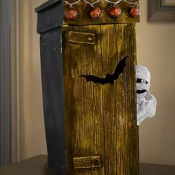 Spooky Outdoor Toilet Mummy Decoration featured in a haunting setting with rustic wooden details and bat motifs.