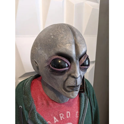 Stylish Realistic Grey Alien Mask latex headgear, showcased on a display, ideal for Halloween and costume parties, available in all sizes.