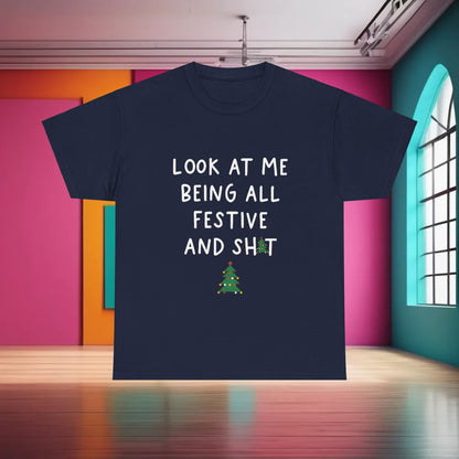 Luxurious Sarcasm Xmas Christmas Graphic T-Shirt with a humorous quote 'LOOK AT ME BEING ALL FESTIVE AND SH*T', displayed in a chic indoor environment.