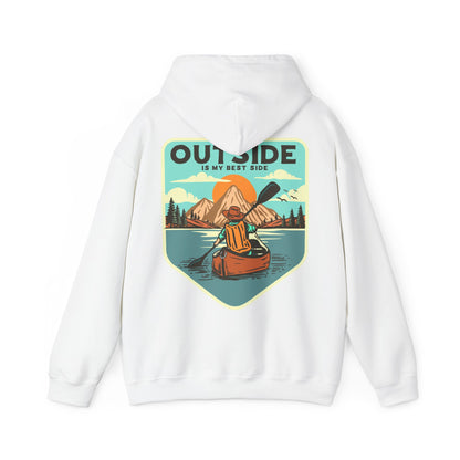 Elegant white hoodie featuring a retro graphic of a kayaker on a serene lake, surrounded by majestic mountains and a sunrise, with the text 'OUTSIDE IS MY BEST SIDE' prominently displayed.