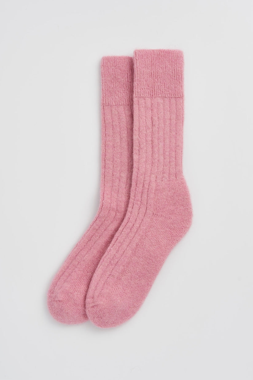Luxury ultra-soft alpaca ribbed bed socks in a cozy setting, highlighting the cushioned sole for ultimate comfort.