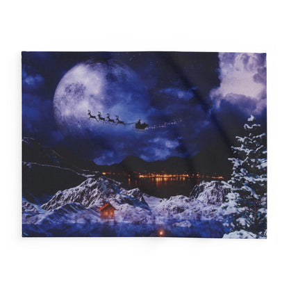 Charming Decorative and Warm Christmas Arctic Fleece Blanket displaying a picturesque snow-covered scene with Santa's enchanting sleigh flying under a glowing moon, ideal for luxurious holiday decor.