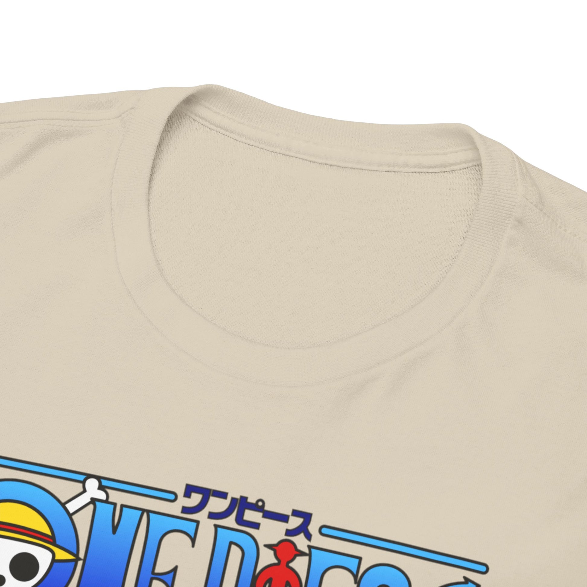 Detailed close-up of the neckline of a luxury beige t-shirt showcasing the iconic One Piece logo and vibrant illustration of Zoro.