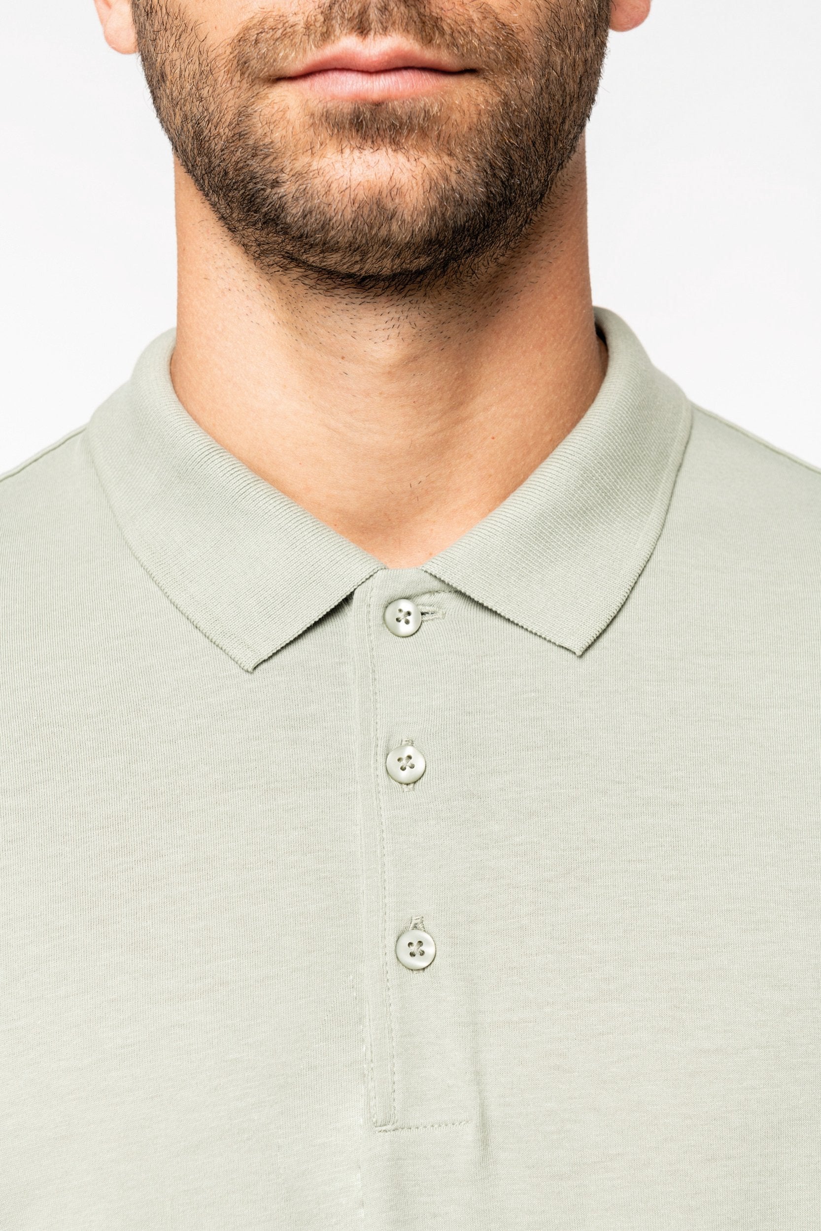 Flat lay of enzyme-washed organic cotton polo shirt for men, featuring smooth fabric and modern appeal.