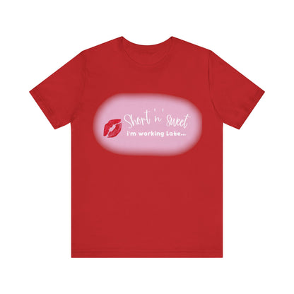 Sabrina Carpenter Inspired Unisex Short Sleeve Tee with Vibrant Lipstick Print in bold red, featuring a playful message 'Short 'n' sweet, I'm working Late...' stylishly crafted for a luxurious feel.