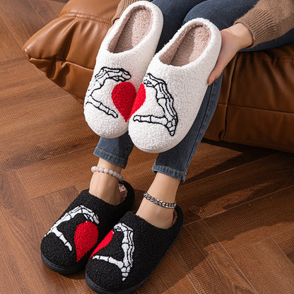 Funny Halloween Love Skull-hand Slippers featuring a whimsical design in soft white and black. Perfect for both men and women, these luxurious non-slip cotton floor slippers provide warmth, comfort, and style, ideal for cold winter evenings.