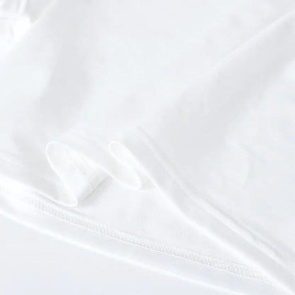 Dazzling Dreams Studio Women's Bless Up Embroidered Crop Tee worn with a midi skirt, showcasing its versatility and ability to elevate any outfit with sophistication.