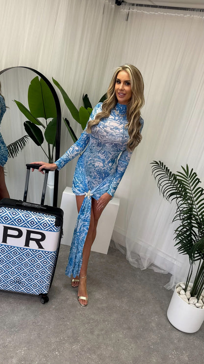 Model wearing the elegant Santorini Dress with sheer print, highlighting the long sleeves and sophisticated silhouette, ideal for stylish summer evenings.