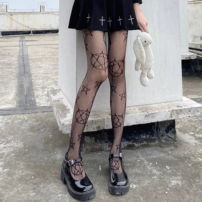 Dazzling Dreams Studio Pentacle Design Fishnet Stockings showcasing elegant black mesh with a pentacle print, paired with a stylish black skirt and chunky black shoes, perfect for making a bold fashion statement.