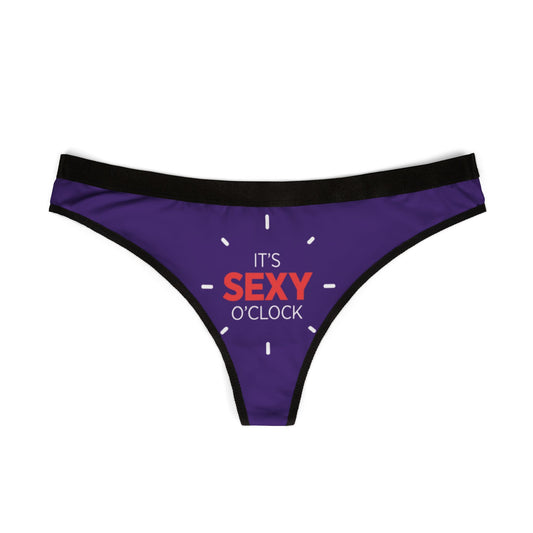 Stylish women's thong showcasing a vibrant 'IT'S SEXY O'CLOCK' print on a luxurious purple fabric, designed for those who appreciate cheeky elegance in their intimate apparel.