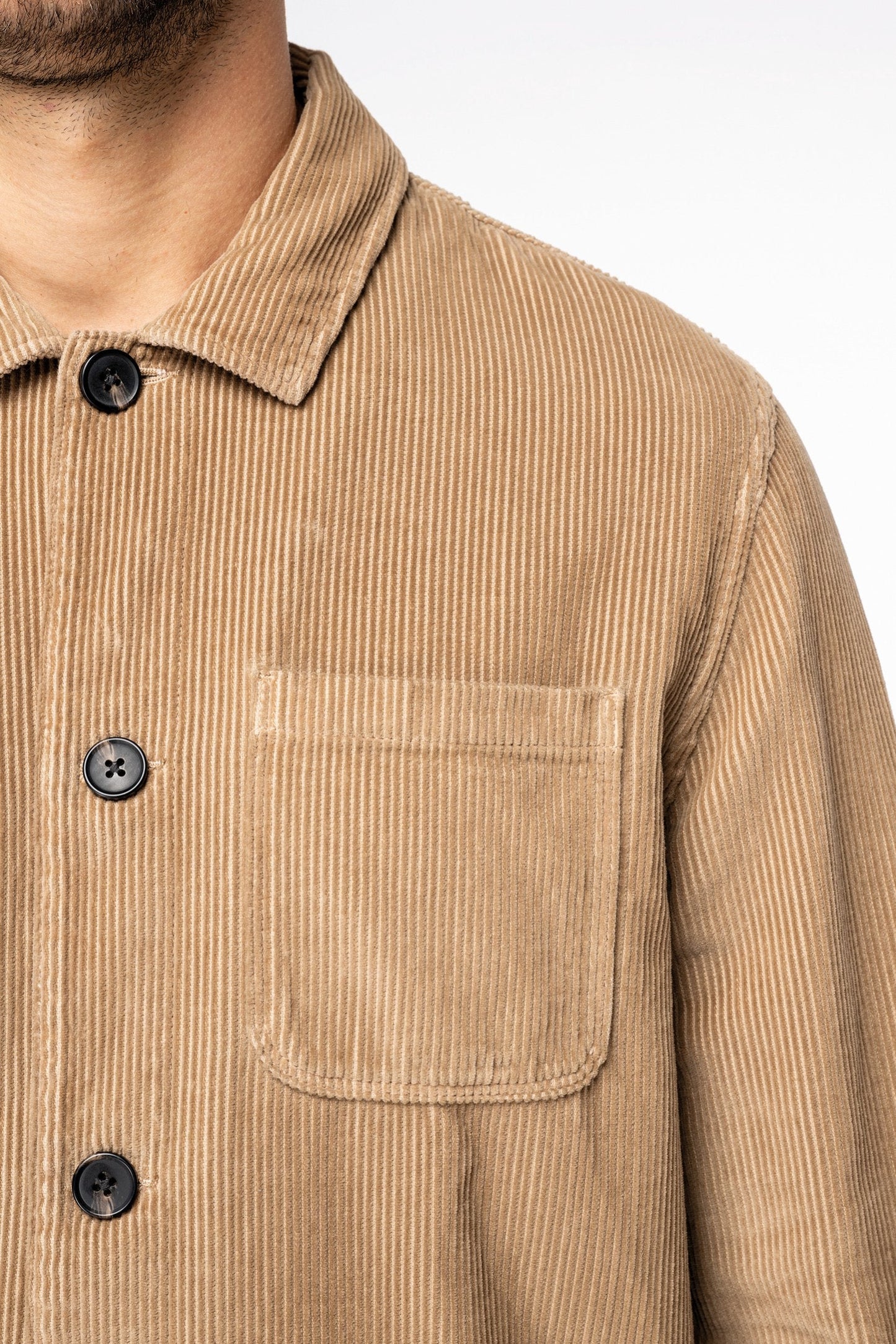 Close-up of recycled plastic buttons on a premium organic cotton corduroy jacket, highlighting eco-conscious fashion and luxurious craftsmanship.