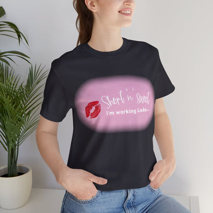 Sabrina Carpenter Inspired Unisex Short Sleeve Tee with Vibrant Lipstick Print, displayed on a model, showcasing the stylish message 'Short 'n' sweet, I'm working Late...' ideal for luxurious casual wear.