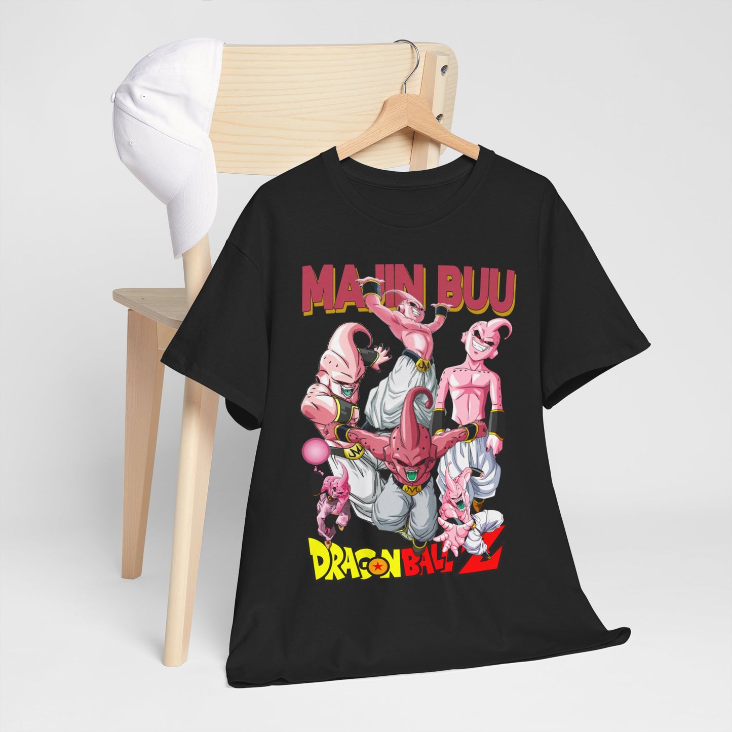Fashionable black t-shirt draped over a wooden chair alongside a white cap, prominently featuring Majin Buu artwork, ideal for anime enthusiasts.