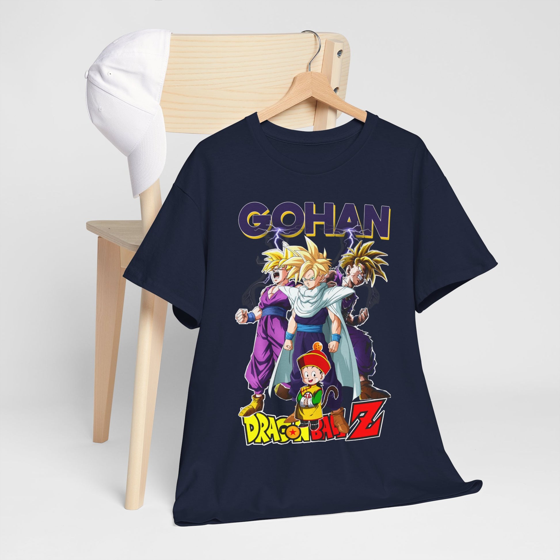 Sophisticated Gohan Ascends T-Shirt displayed on a wooden chair, accentuated with a stylish cap, radiating contemporary anime culture and high-end apparel.