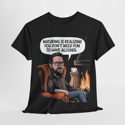 Maturing with Alcohol Graphic T-Shirt Urban Unisex Cotton Tee featuring a lively cartoon design of a gentleman sitting in an armchair by a fireplace, holding a glass of whiskey and complemented by the witty phrase, 'Maturing is Realizing You Don't Need Fun to Have Alcohol'.