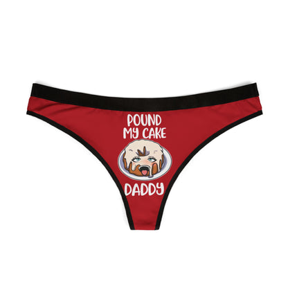 Elegant red women's thong adorned with a whimsical cake illustration and the cheeky text 'POUND MY CAKE DADDY', designed for playful and flirtatious moments.