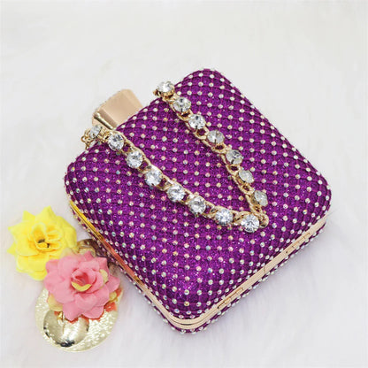 Chic purple handbag with a metallic handle, matching the luxury women's sandals, ideal for elegant occasions.
