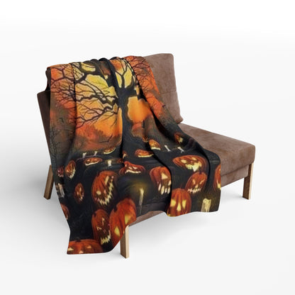 Decorative and Warm Halloween Spooky Arctic Fleece Blanket draped stylishly over a cosy armchair, featuring a haunting autumn landscape with carved jack-o'-lanterns under an eerie tree.