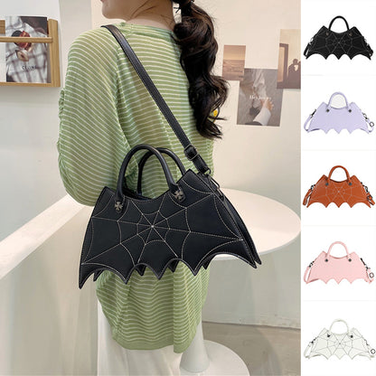 Elegant black Halloween Spider Web Shape Shoulder Bag showcased by model wearing a striped green top, highlighting its unique Batgirl design for fashion-savvy individuals.