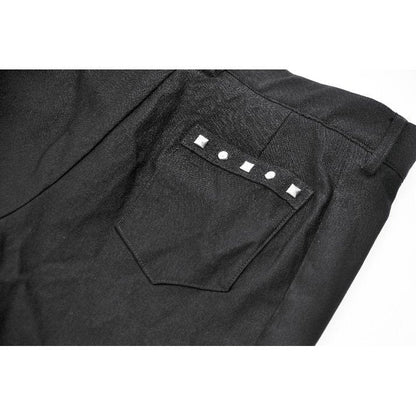 Model wearing high-waisted black garter shorts styled with fishnet tights and platform boots, perfect for a goth-punk ensemble.