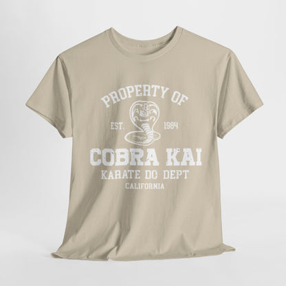 Elegant beige t-shirt featuring the iconic Cobra Kai logo and text, showcasing a vintage design from 1984. Perfect for karate enthusiasts and fans of martial arts humour, this unisex graphic tee blends style with nostalgia.