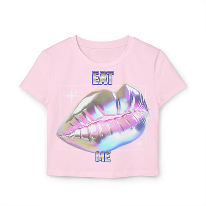 Delicate pink cropped t-shirt featuring a glossy holographic lips motif alongside the whimsical text 'EAT ME' in vivid blue, made from premium organic cotton for a trendy yet sophisticated appearance.