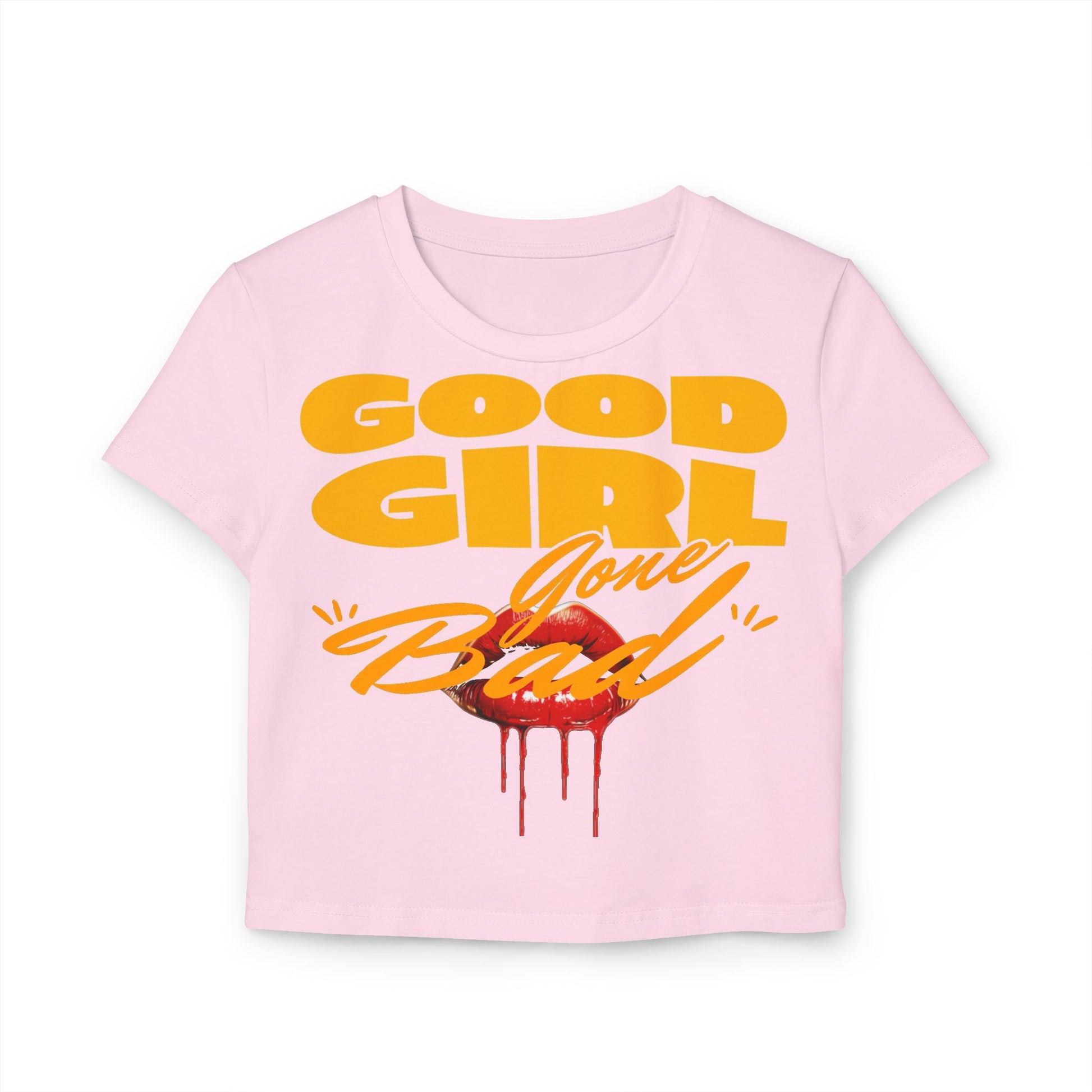 Close-up of a luxurious cropped Baby T-shirt in soft pink, adorned with a bold 'Good Girl Gone Bad' graphic and luscious red lips, blending cheekiness with refined style.