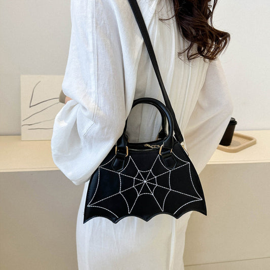 Elegant black Halloween Spider Web Saddle Bag worn crossbody, showcasing luxurious design with detailed spider web stitching, ideal for stylish celebrations.