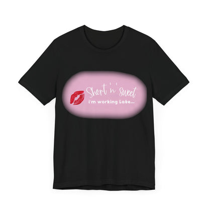 Front view of the stylish Sabrina Carpenter Inspired Unisex Short Sleeve Tee showcasing a vibrant lipstick print with a playful tagline in pink.