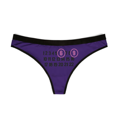 Front view of the Enigmatic 69 Thong featuring a cheeky number design with '6' and '9' circled in pink, set on a rich purple backdrop, perfect for those embracing allure and confidence in luxury lingerie.