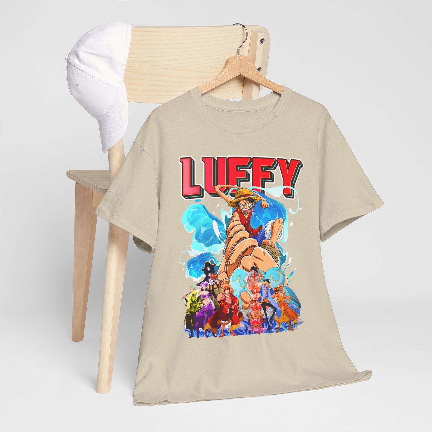 Elegant men's graphic t-shirt featuring vibrant Luffy design from One Piece, displayed on a wooden hanger with a chic white cap in the background.