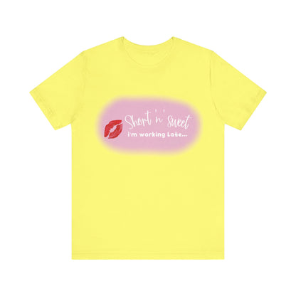 Sabrina Carpenter Inspired Unisex Short Sleeve Tee in vibrant yellow featuring a chic lipstick motif with the phrase 'Short n sweet, i'm working Late...' for a stylish, luxurious look.