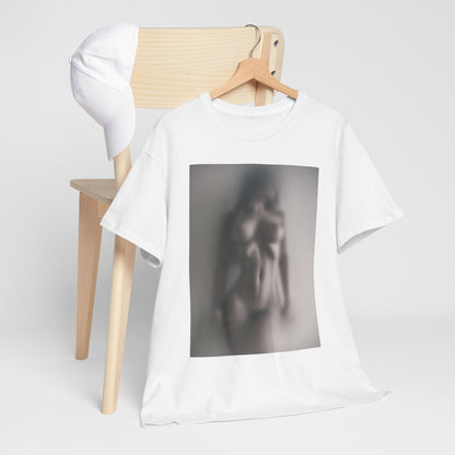 Elegant white graphic t-shirt displayed on a wooden chair, featuring a captivating blurred image of a nude figure, evoking intrigue and artistry.