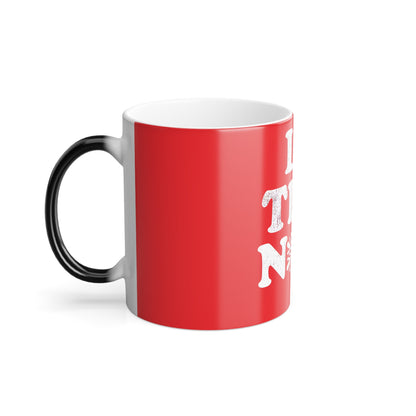 Side profile of Let It Snow Le Tits Now Christmas Color Morphing Mug, featuring a stylish black handle and vibrant red surface, a delightful addition to any luxury holiday collection.